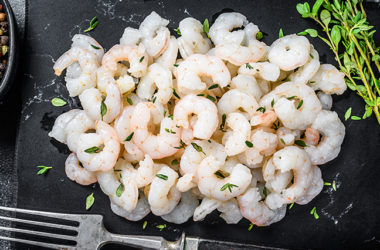 Peeled Shrimps, Prawns on a marble board. Black background. top view.